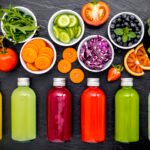 colourful healthy smoothies and juices in bottles with fresh tro